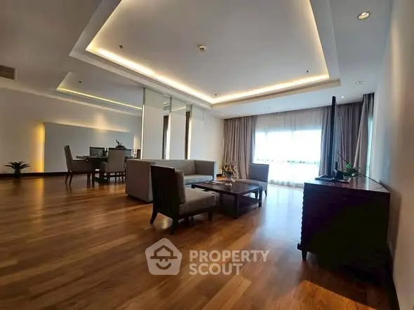 Spacious modern living room with elegant wooden flooring and stylish ceiling lights.