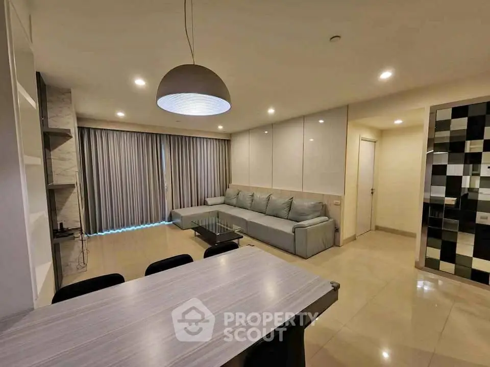 Spacious modern living room with elegant lighting and cozy seating area.
