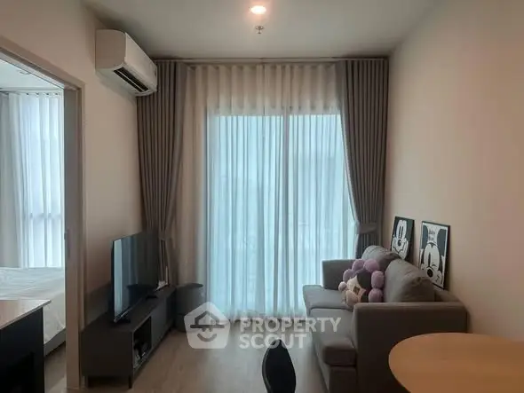 Modern living room with cozy sofa, TV, and large window with curtains in a stylish apartment.