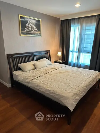 Cozy bedroom with wooden flooring and elegant decor