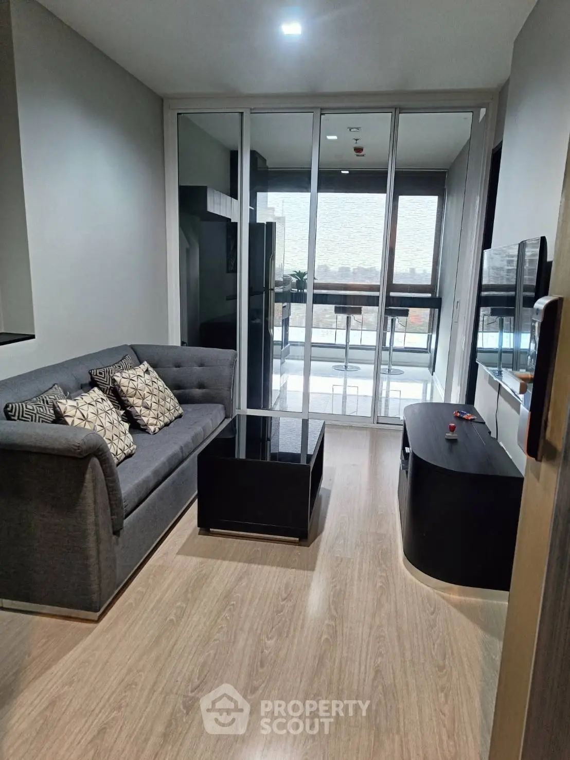 Modern living room with sleek furniture and balcony view in urban apartment