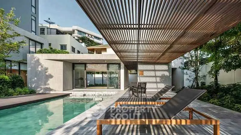 Luxurious modern home with sleek poolside lounge area and contemporary architecture.