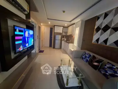 Modern living room with sleek design, featuring a wall-mounted TV, stylish sofa, and contemporary kitchen area.