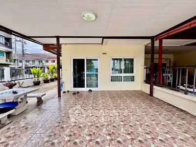 Spacious tiled balcony with seating area and sliding glass doors in a modern home.