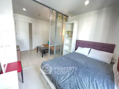 Modern bedroom with sliding glass doors and cozy decor in a stylish apartment.