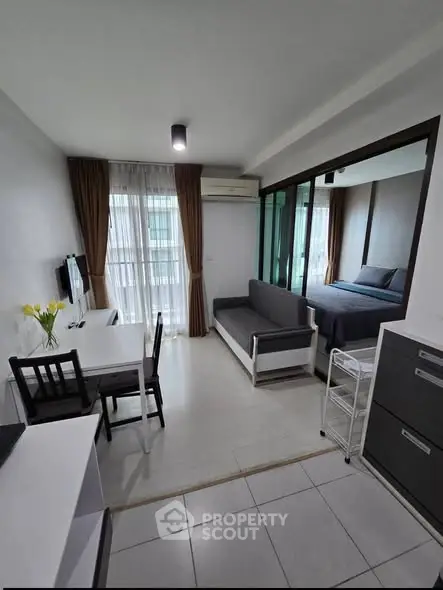 Modern studio apartment with open layout, featuring a cozy living area and bedroom with natural light.