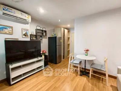 Modern living room with wooden flooring, stylish decor, and a cozy dining area in a contemporary apartment.