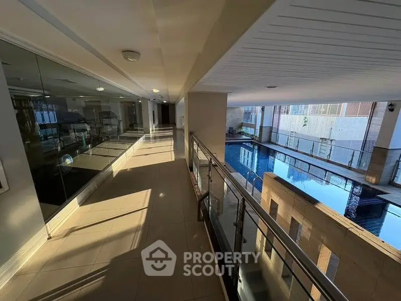 Luxurious indoor pool area with modern design and glass railings in a high-end residential building.