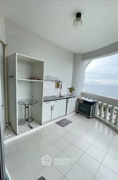 Spacious balcony with ocean view and outdoor kitchenette, perfect for relaxation and entertaining.