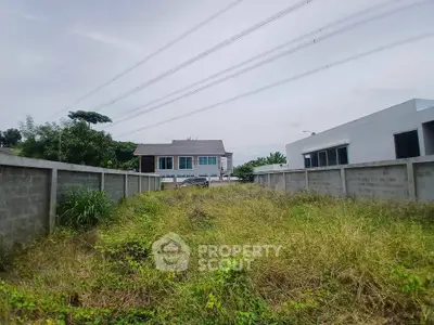 Spacious residential plot with lush greenery and modern surrounding homes