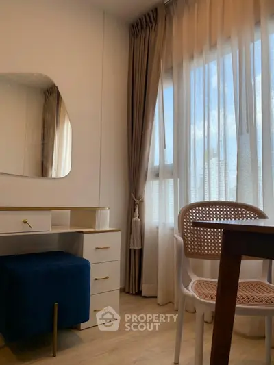 Chic study area with elegant furniture and natural light from large window.