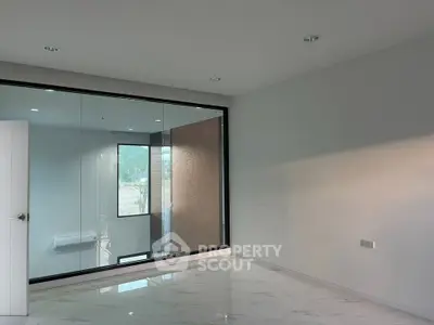 Spacious modern room with large glass window and sleek marble flooring