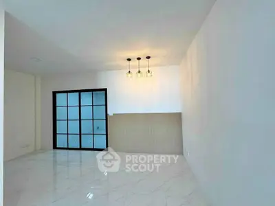 Spacious modern living room with elegant lighting and sleek tile flooring.