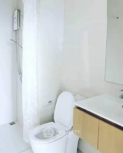 Modern bathroom with sleek fixtures and minimalist design, featuring a shower and vanity.