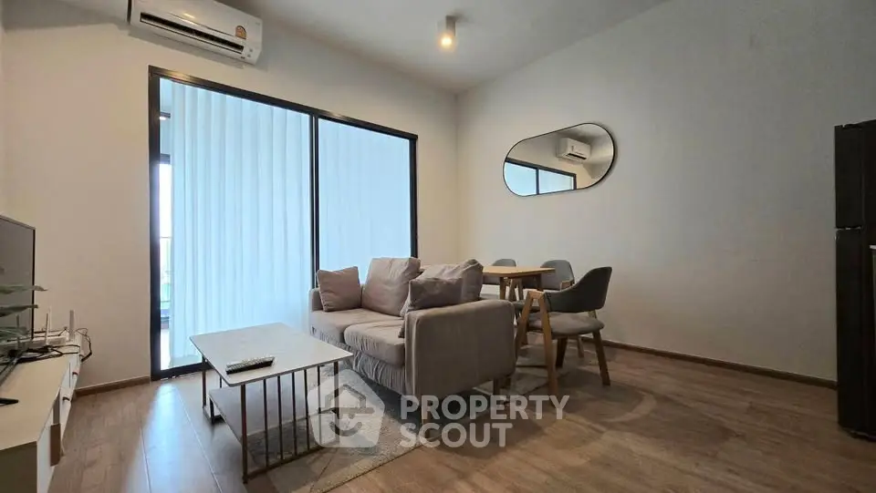 Modern living room with sleek furniture and large window for natural light.