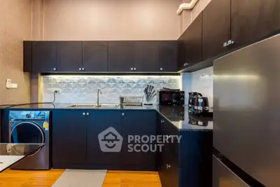 Modern kitchen with sleek black cabinets and stainless steel appliances