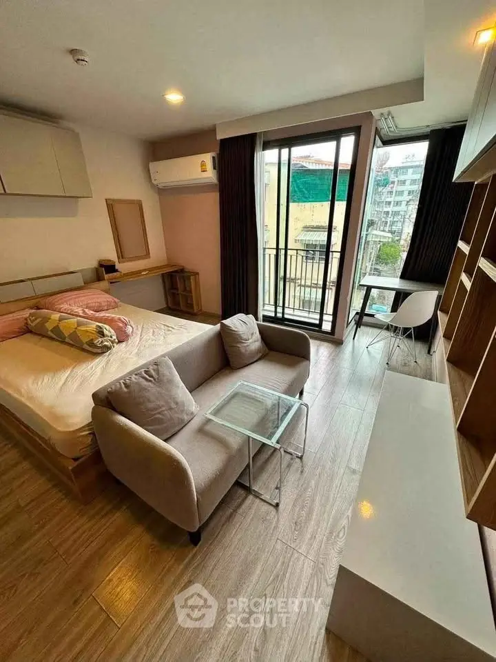 Modern studio apartment with cozy living area and balcony view
