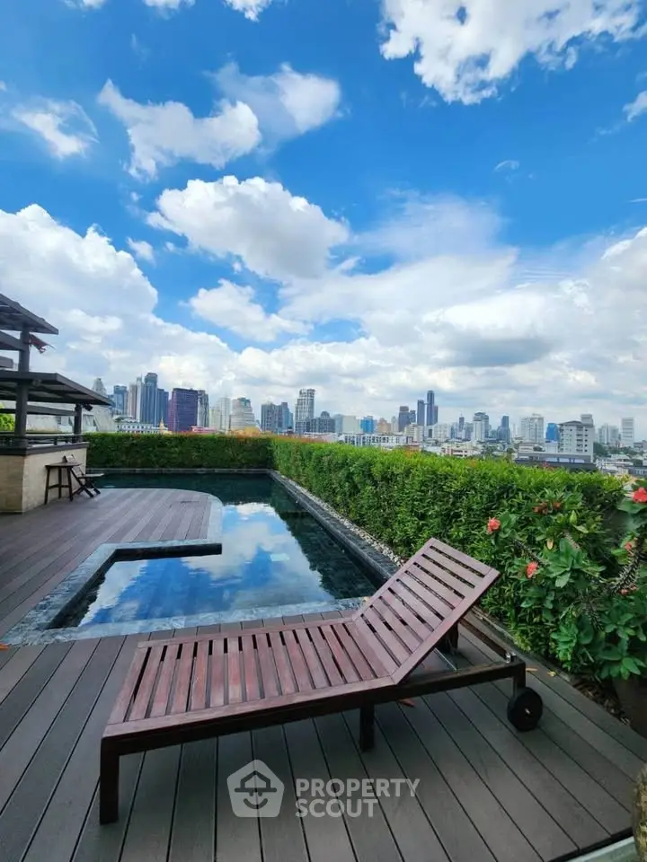 Luxurious rooftop pool with stunning city skyline view and elegant wooden deck.