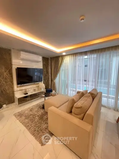 Luxurious living room with modern decor, plush sofa, and large TV, featuring elegant lighting and floor-to-ceiling windows.