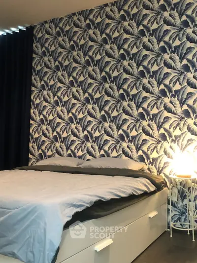 Stylish bedroom with tropical wallpaper and cozy lighting