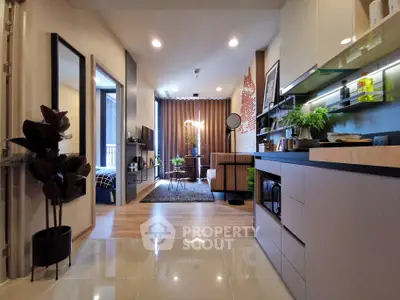 Modern open-layout living room and kitchen with stylish decor and natural light.