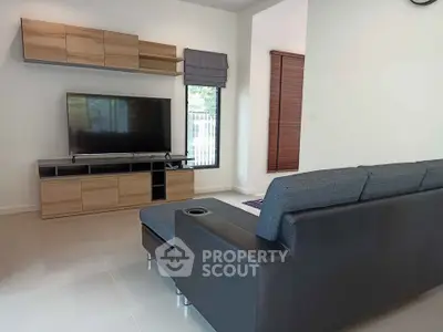 Modern living room with sleek furniture and large TV, perfect for relaxation and entertainment.