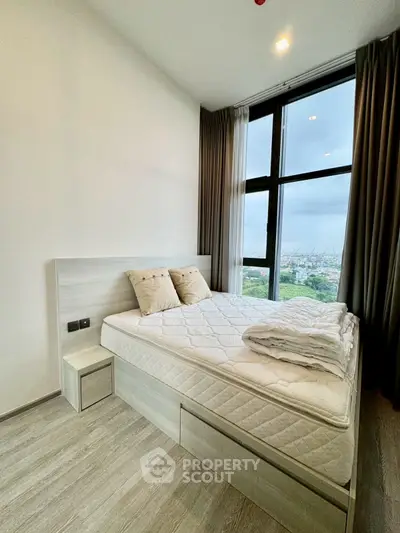 Modern bedroom with large windows offering stunning city views, featuring a cozy bed and elegant decor.