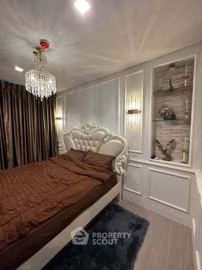 Luxurious bedroom with elegant chandelier and plush decor, featuring a regal bed and ambient lighting.