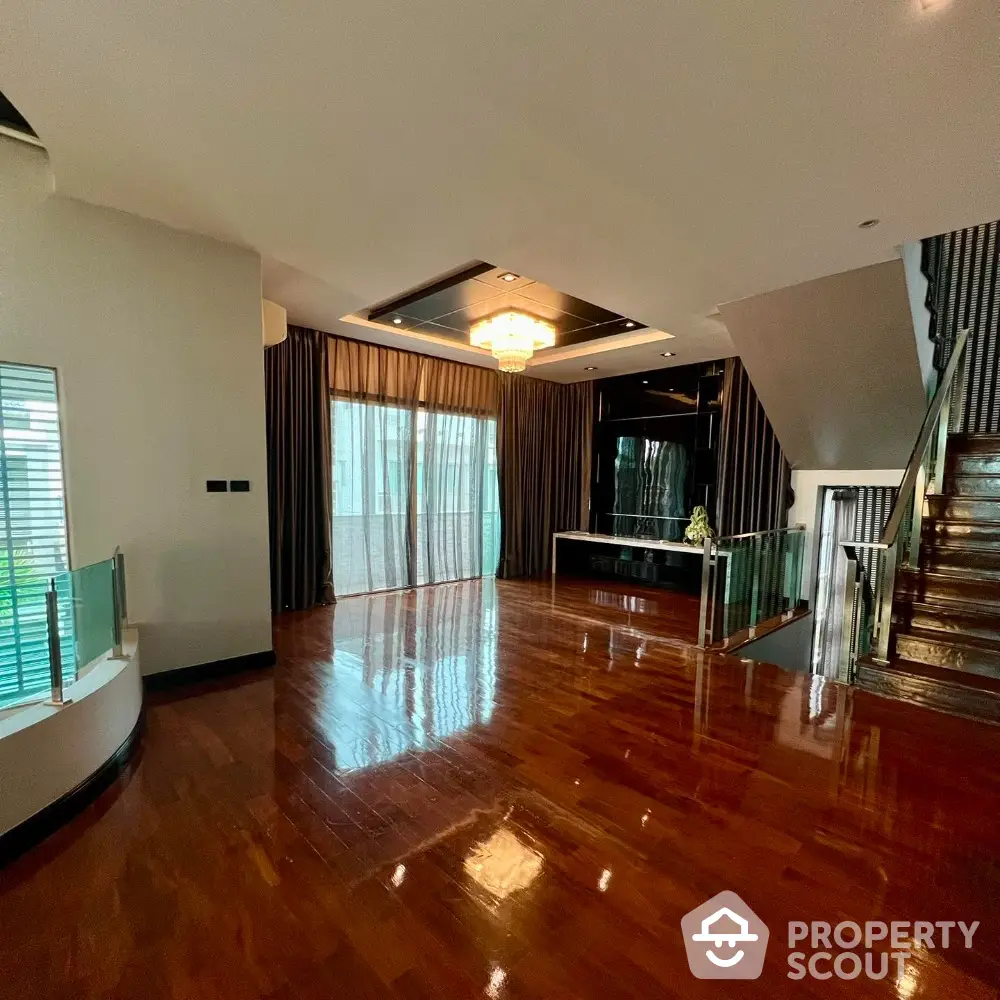 Luxurious living room with polished wooden floors and elegant chandelier