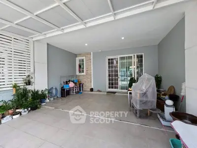 Spacious covered patio with tiled flooring and sliding glass doors, perfect for outdoor relaxation.