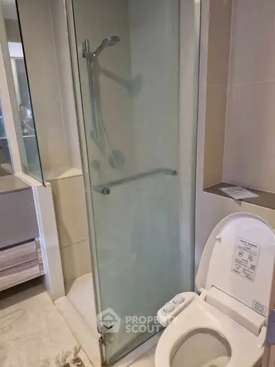 Modern bathroom with glass shower and bidet toilet in a stylish apartment.