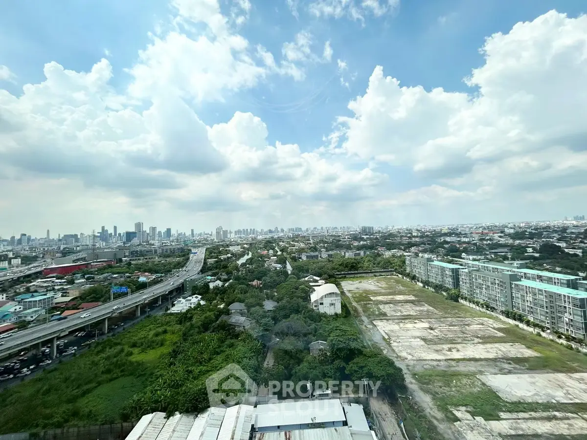 Stunning cityscape view from high-rise building with lush greenery and urban skyline.
