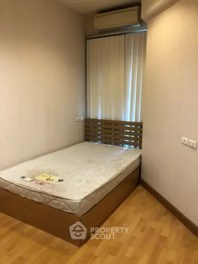 Cozy bedroom with wooden flooring and air conditioning, perfect for restful nights.