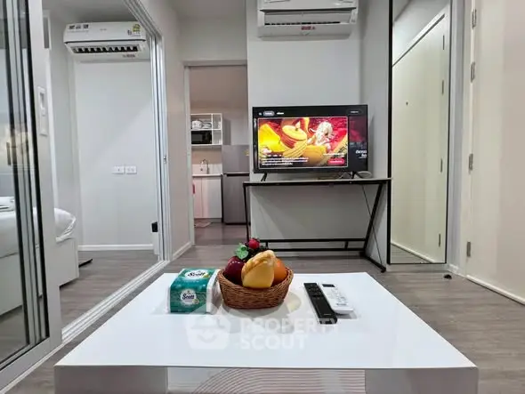 Modern living room with sleek design, featuring a TV, air conditioning, and stylish decor in a cozy apartment.