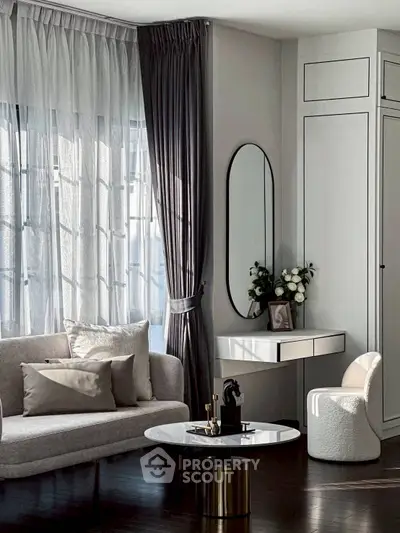 Elegant living room with modern decor, featuring a cozy sofa, stylish coffee table, and chic wall mirror.