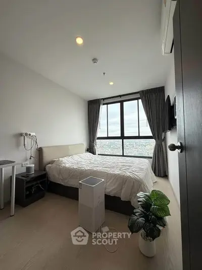 Modern bedroom with large window offering stunning city view, minimalist decor, and air purifier for comfort.