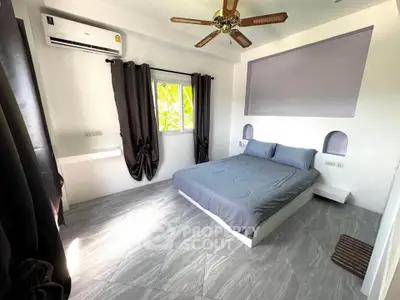 Modern bedroom with sleek design, featuring a ceiling fan, air conditioning, and stylish gray decor.