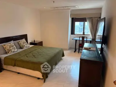 Spacious bedroom with city view, elegant furniture, and natural light.