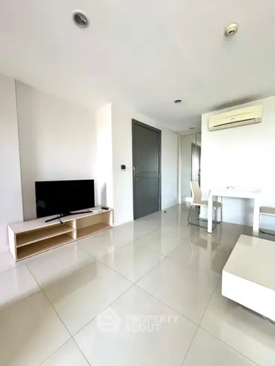 Modern minimalist living room with sleek white furniture and wall-mounted TV