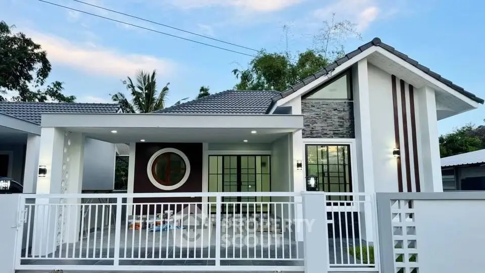 Modern single-story house with unique circular window and sleek design.