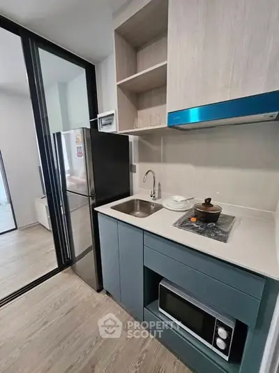 Modern kitchen with sleek cabinetry, compact layout, and built-in appliances in a stylish apartment.