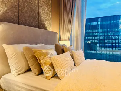 Luxurious bedroom with plush pillows and stunning city view through large window.