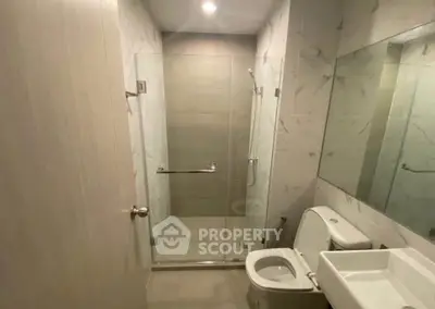 Modern bathroom with glass shower and sleek fixtures in a contemporary apartment.
