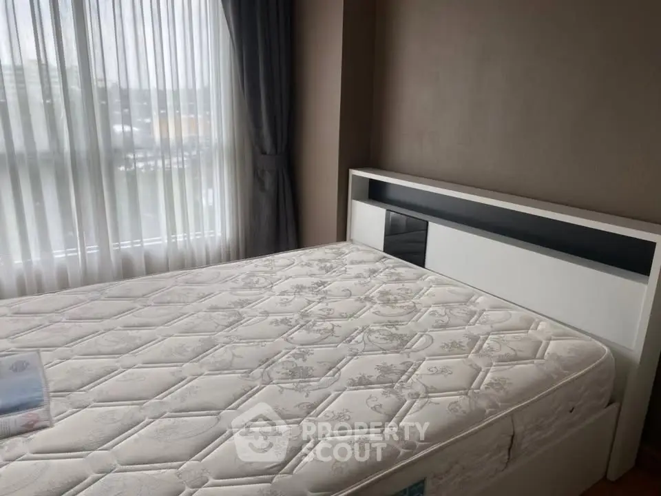 Spacious bedroom with large window and modern bed frame, perfect for natural light lovers.