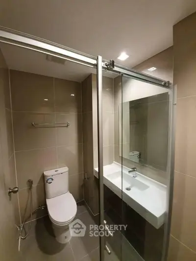 Modern bathroom with sleek glass shower and contemporary fixtures.