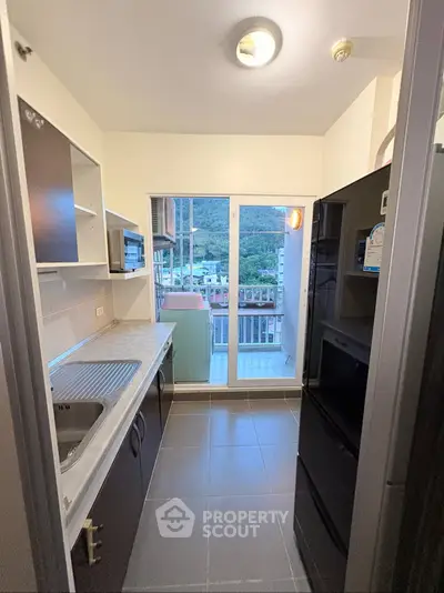 Modern kitchen with balcony view in a high-rise apartment