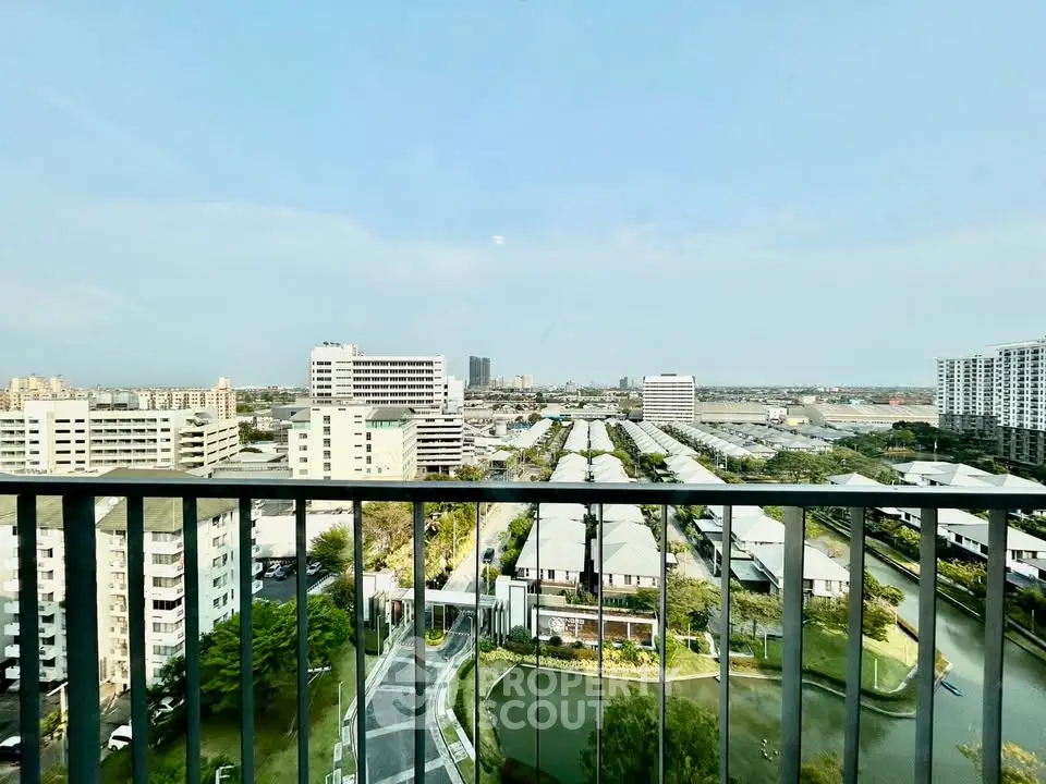Stunning cityscape view from a high-rise balcony overlooking modern buildings and lush greenery.