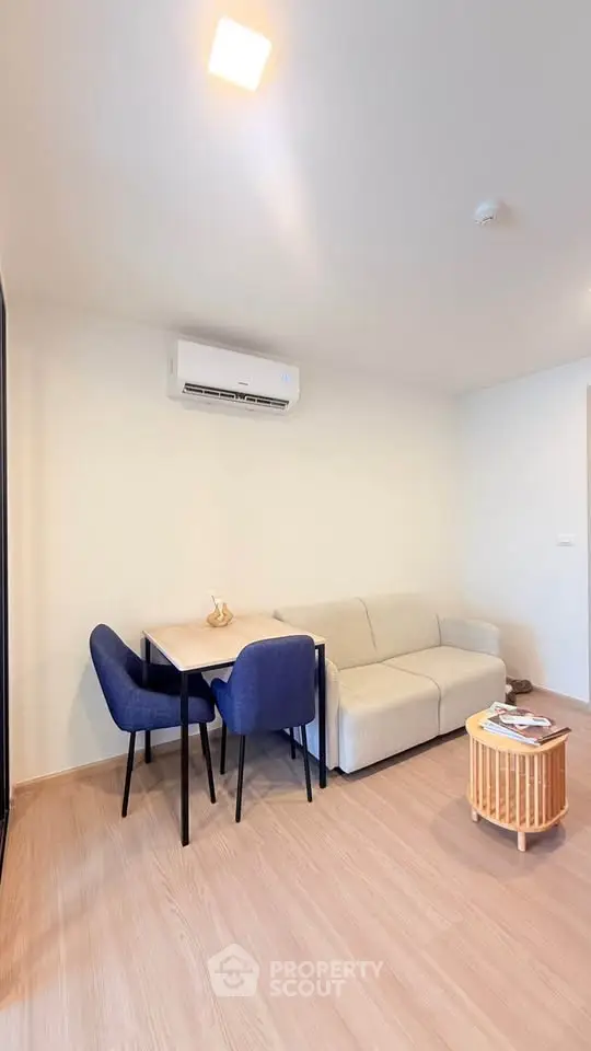 Modern living room with cozy sofa, dining table, and air conditioning in a bright apartment.