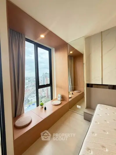 Luxurious bedroom with panoramic city view and cozy window seating area.