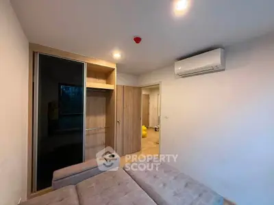 Modern bedroom with built-in wardrobe and air conditioning unit